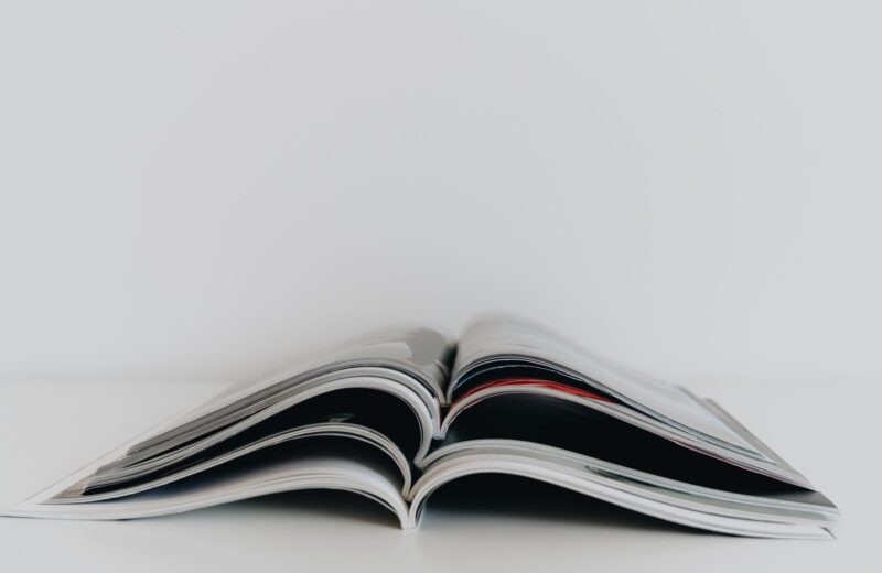 An open printed magazine lying on a white table