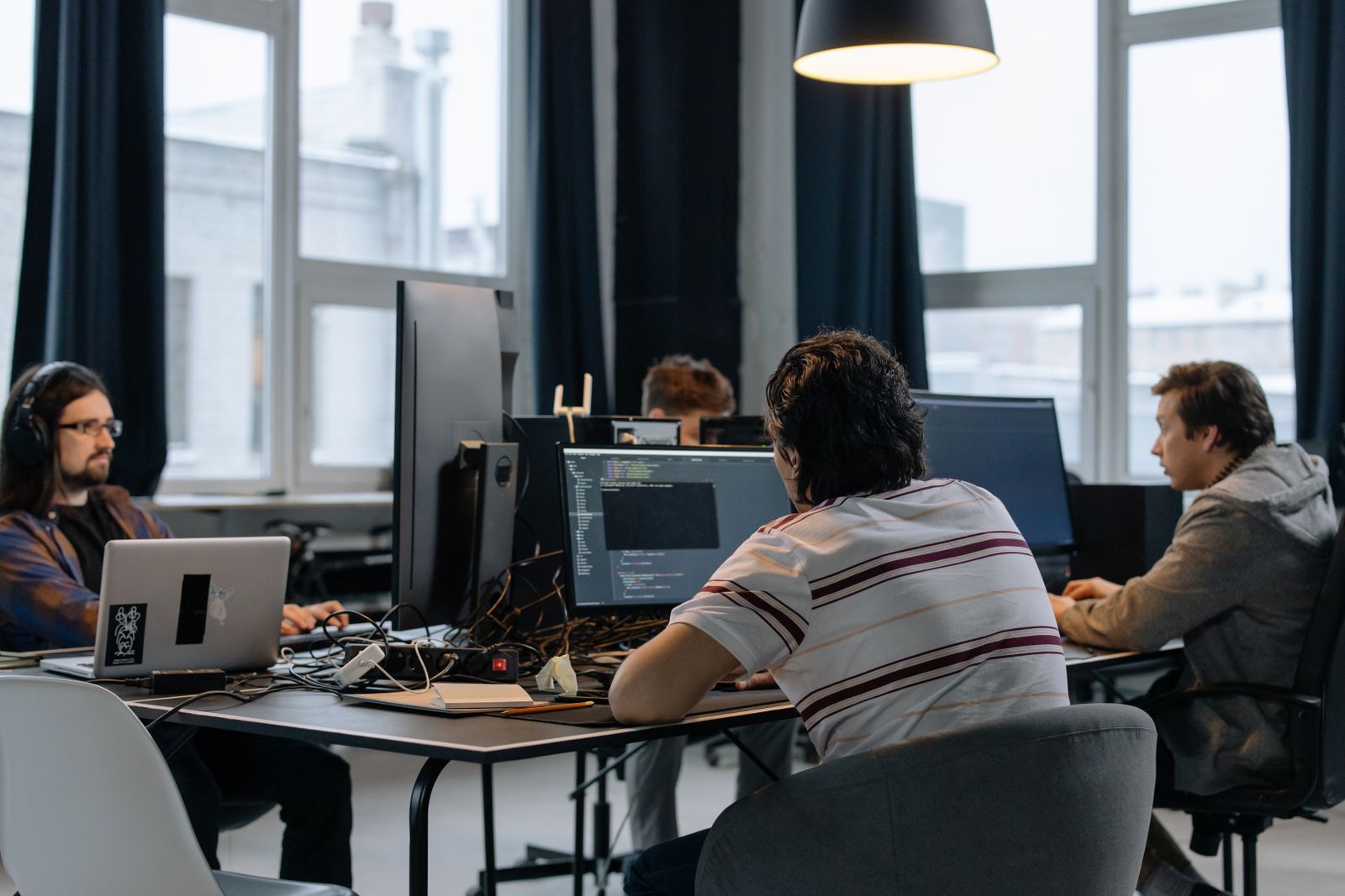 Developers working side by side at desks with large screens