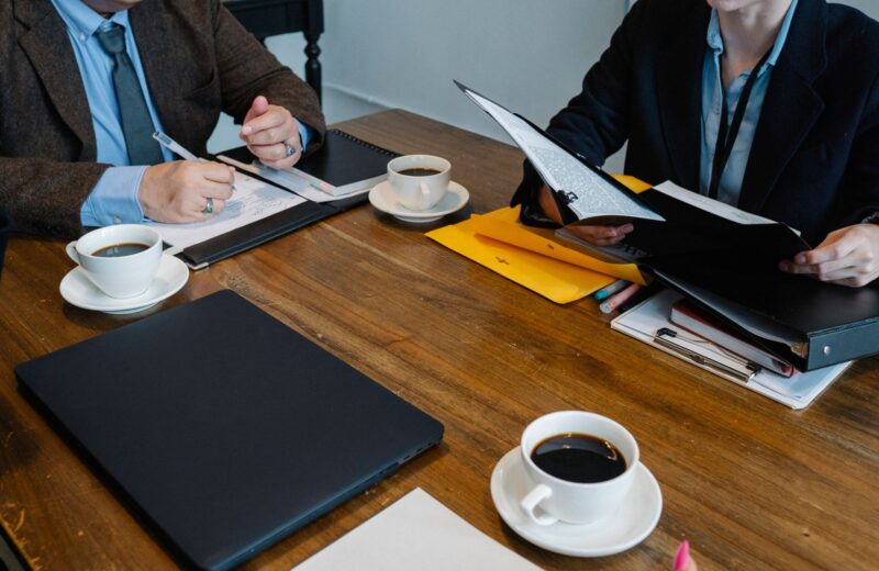 Colleagues at a table with documents and cups of coffee