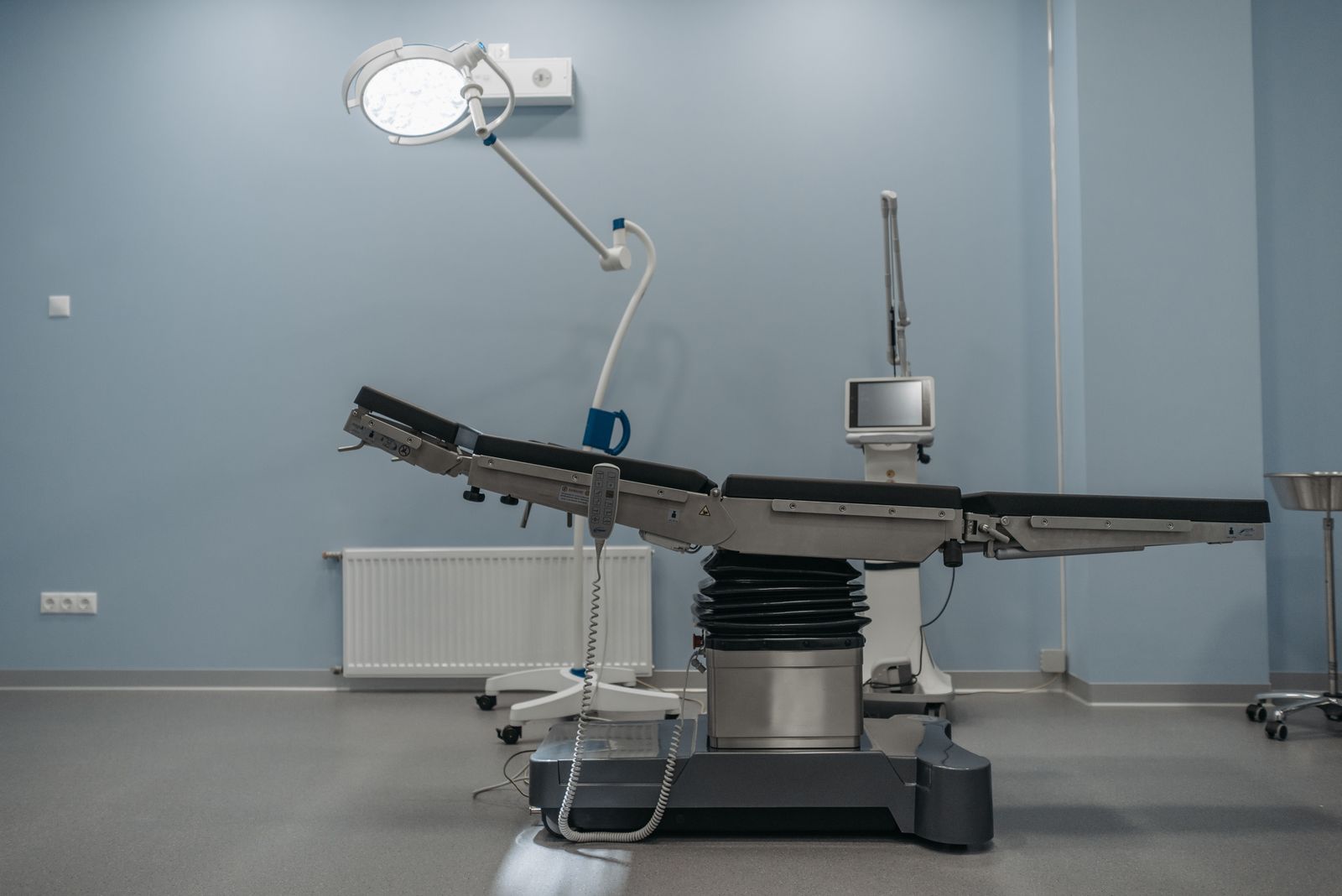 An empty operating theatre with the table, lights and monitors ready