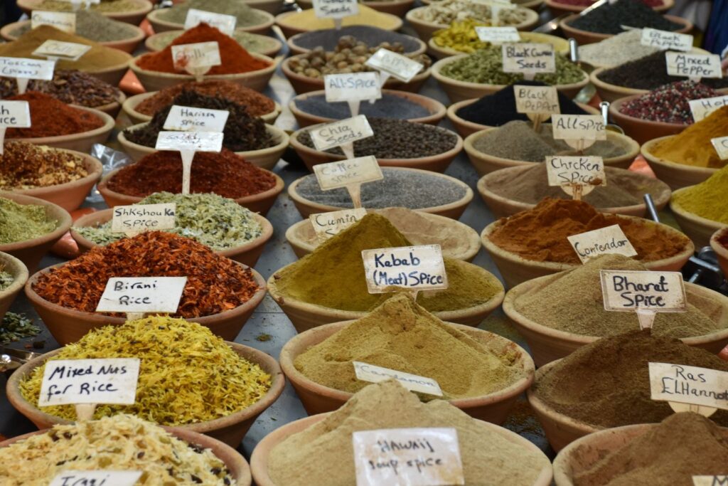 Wooden bowls of ground spices with handwritten name cards, seen from above