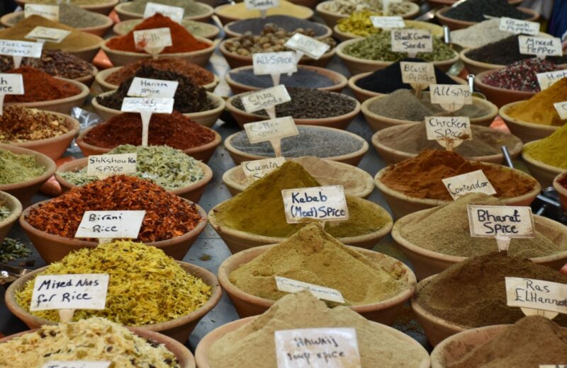 Wooden bowls of ground spices with handwritten name cards, seen from above