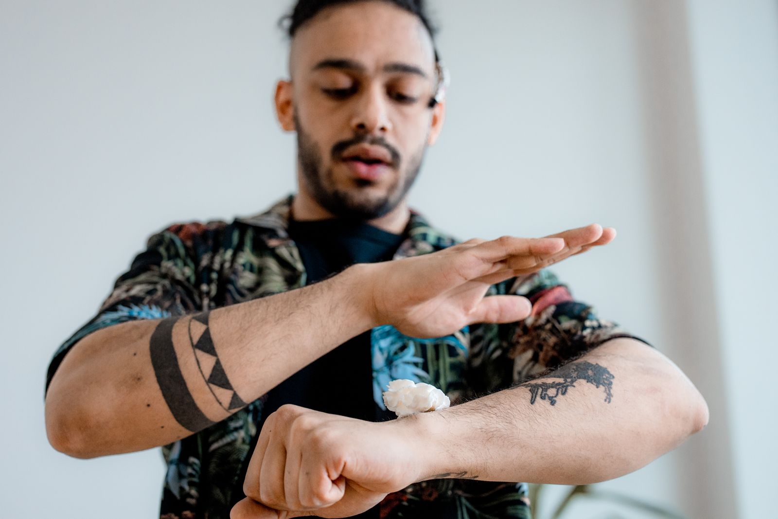 A man rubbing aftercare cream into the tattoos on his forearm
