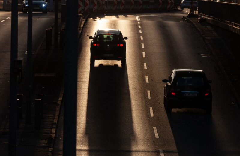 Cars driving along a city road in the evening light