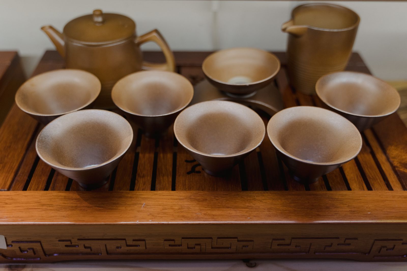 Small ceramic tea cups on a wooden tea tray ready for a gongfu session