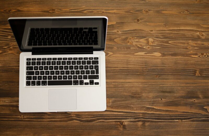 An open laptop seen from above on a dark wooden desk