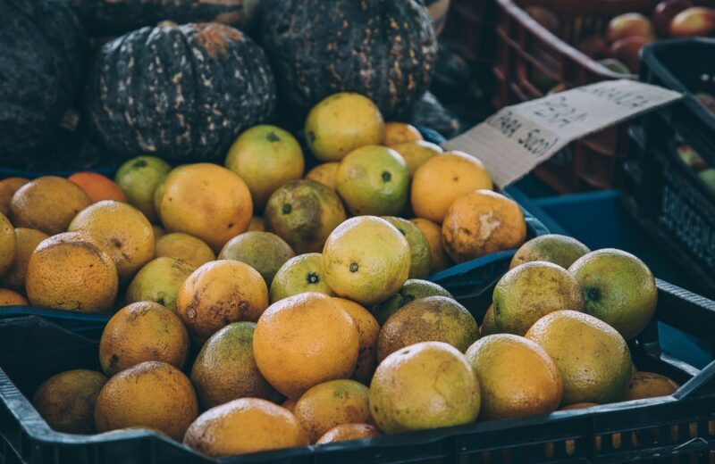 A basket of oranges and lemons on a market stall