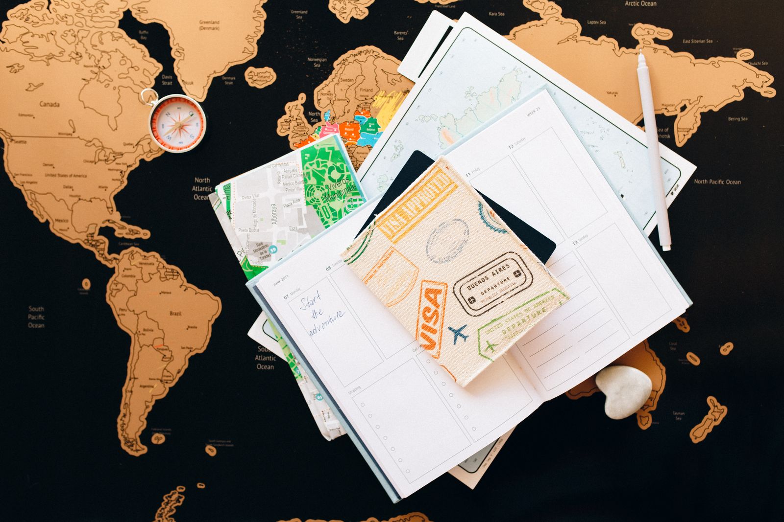 A map, a compass and a guidebook laid out for planning a trip
