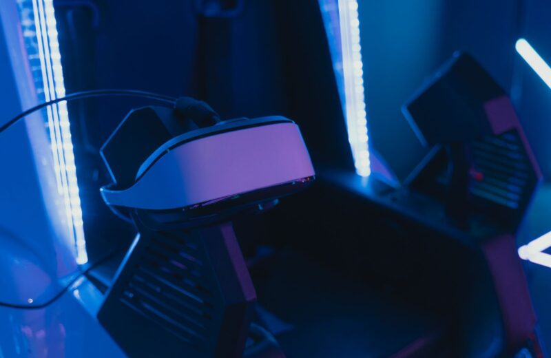 A VR headset resting on a seat under blue light strips