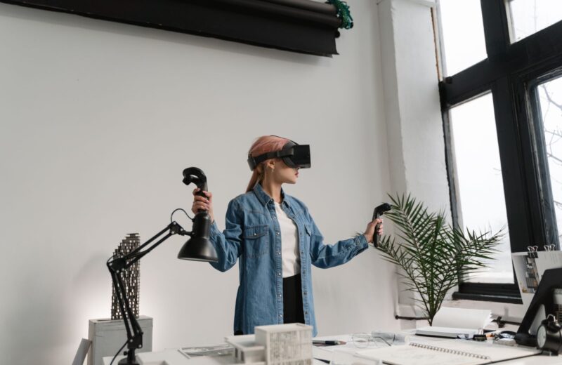 A woman in a VR headset and denim jacket testing a build in an office