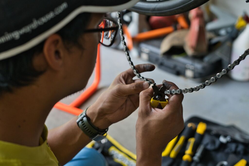 Mechanic's hands fitting a bicycle chain in a workshop