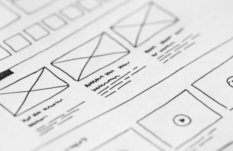 Close-up of hand-drawn page wireframes on paper