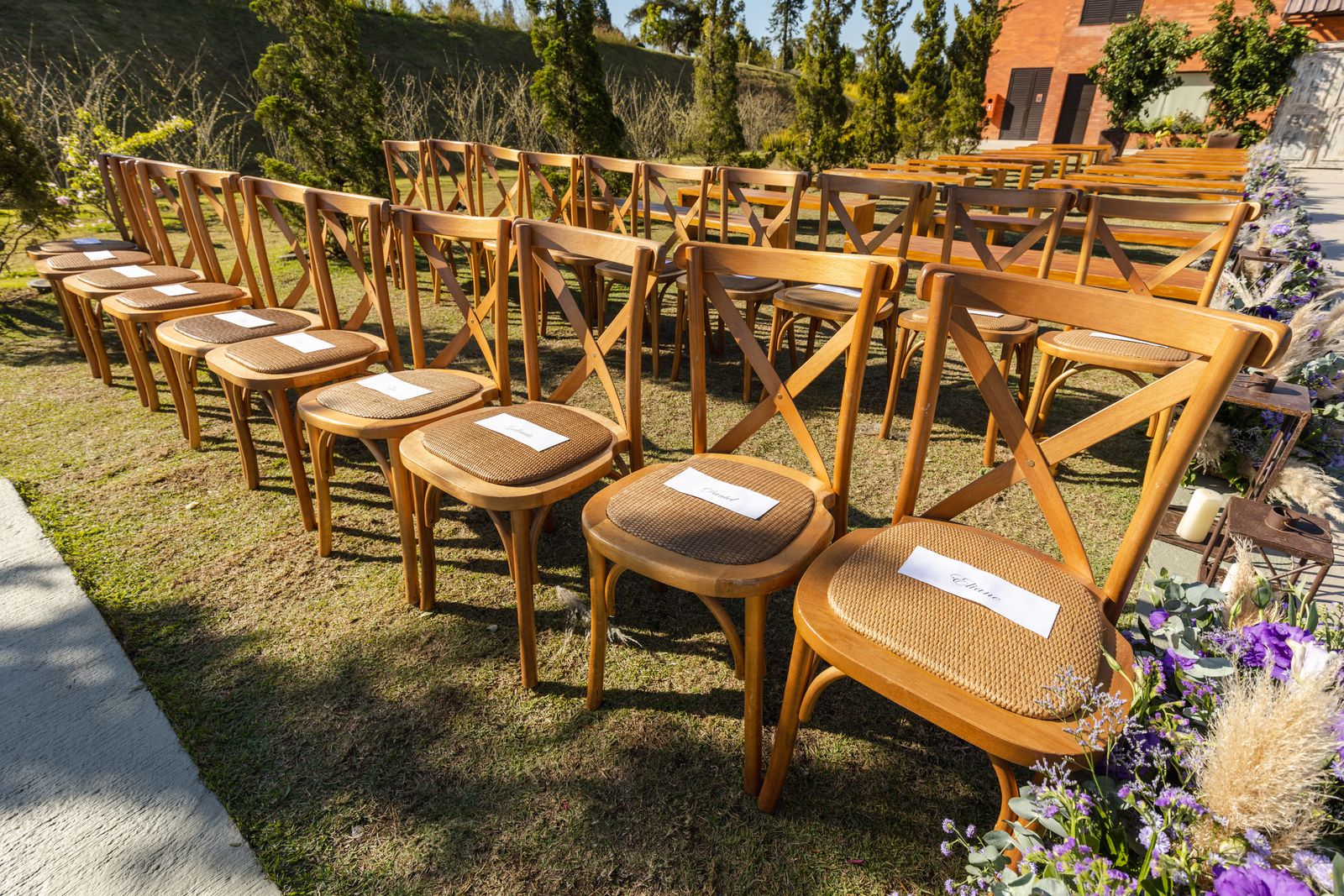 Rows of wooden chairs set out on the grass for an outdoor ceremony