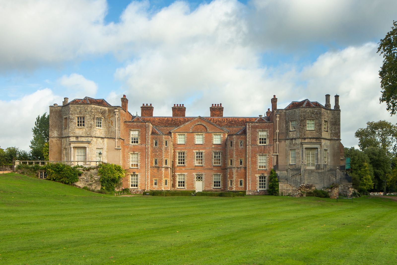 A stone country house with a wide lawn in front