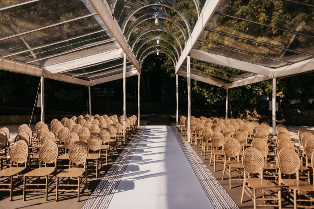 Chairs set in rows under a clear canopy for a ceremony