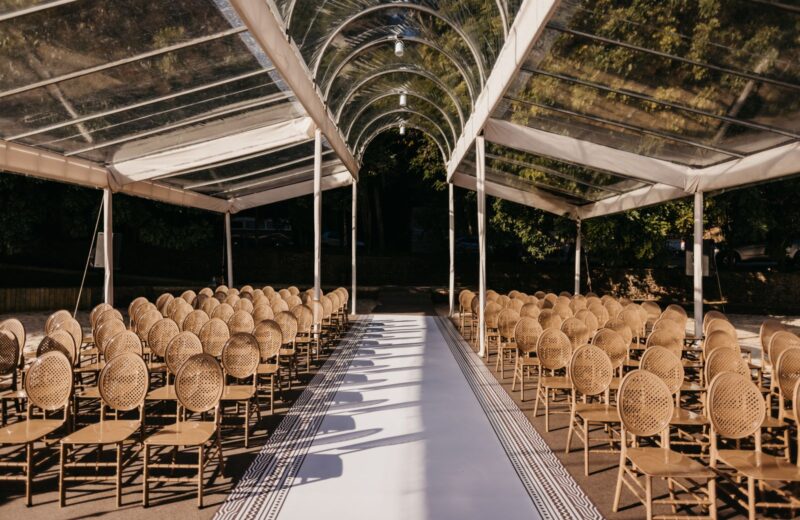 Chairs set in rows under a clear canopy for a ceremony