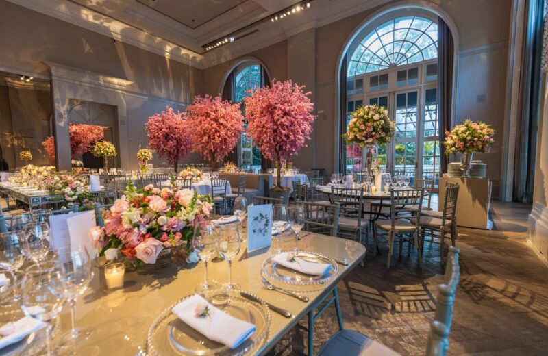 Tables with tall flower arrangements in a reception hall
