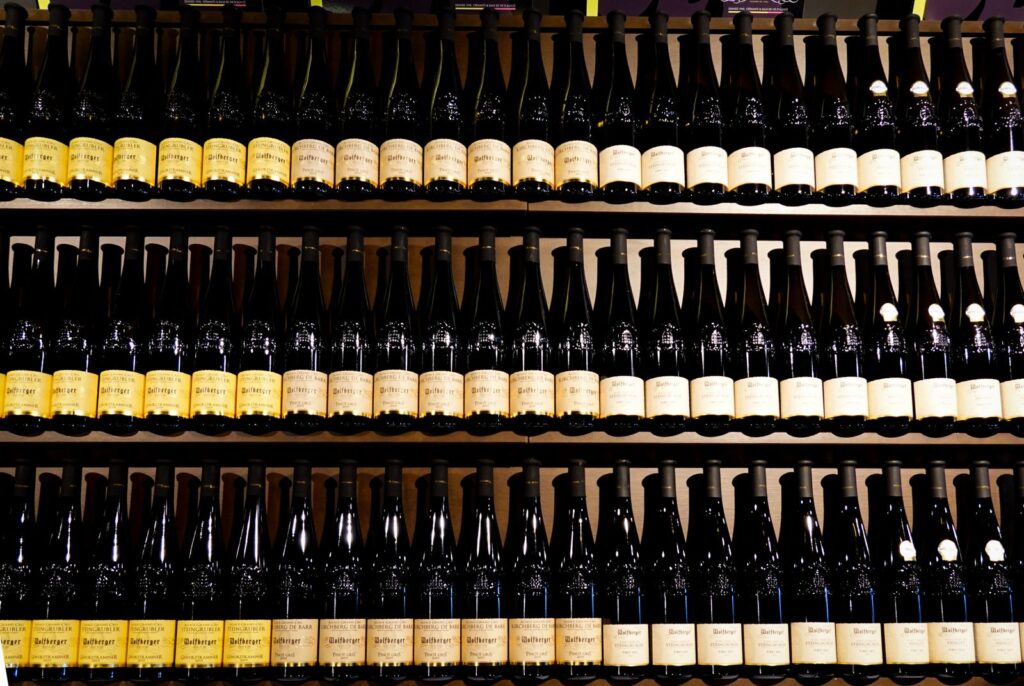 Rows of wine bottles standing on shop shelves