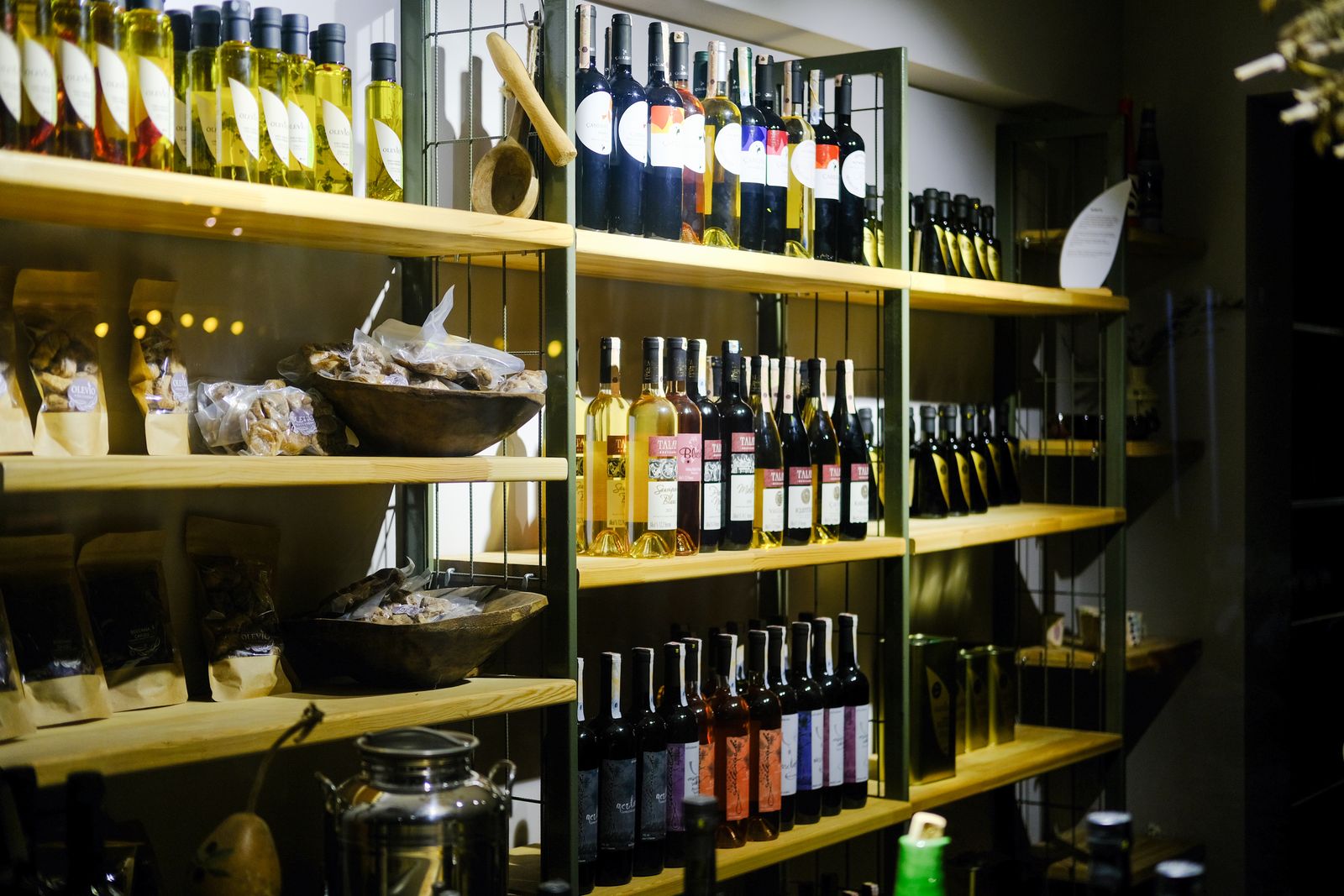 Wine bottles on wooden shelves along the wall of a small wine shop