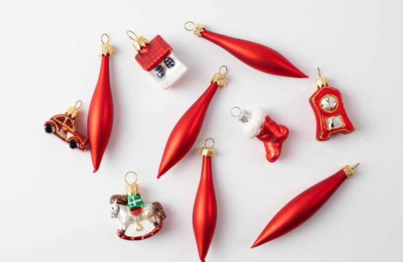 Red glass Christmas ornaments laid out on a white table