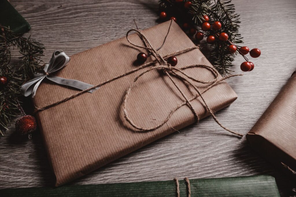 A gift wrapped in kraft paper and tied with twine on a rustic table